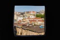 Black frame, view from a small window opening to the old city, minaret, old houses, roofs of houses.